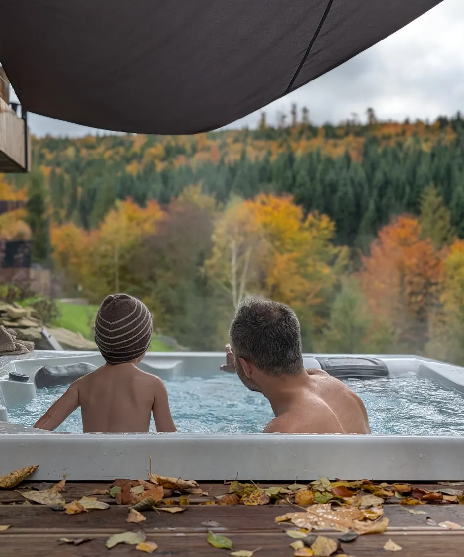 Tata z dzieckiem w jacuzzi na tle jesiennego lasu